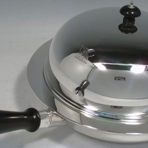 Sterling silver chafing dish, having a plain round body, a domed lid with wooden finial, a pair of loop side handles, and the body having an interior heating compartment that can be filled with hot water after unscrewing the wooden handle. Made by Charles Boyton and sons of London in 1922. The dimensions of this fine hand-made dish are length including handle 38 cms (15 inches), diameter 23 cms (9 inches), height 13 cms (5 inches), and the weight without handle is approx. 1,240g (40 troy ounces). Please note that the lid is crested.