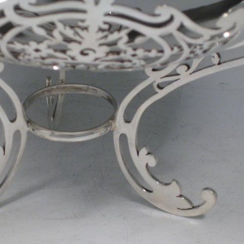 A very pretty Antique Sterling silver dish, having a plain rounded semi-triangular shaped body with central dimple, a hand-cut shaped and pierced border, and sitting on three pierced foliate feet with central strengthening ring. This beautiful silver raised dish was made by Walker and Hall of Sheffield in 1920. The dimensions of this fine hand-made antique silver dish are height 14 cms (5.5 inches), width 21 cms (8.25 inches), and it weighs approx. 520g (16.8 troy ounces). 