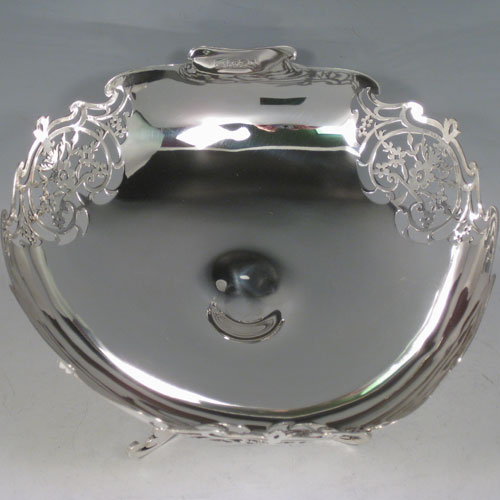 A very pretty Antique Sterling silver dish, having a plain rounded semi-triangular shaped body with central dimple, a hand-cut shaped and pierced border, and sitting on three pierced foliate feet with central strengthening ring. This beautiful silver raised dish was made by Walker and Hall of Sheffield in 1920. The dimensions of this fine hand-made antique silver dish are height 14 cms (5.5 inches), width 21 cms (8.25 inches), and it weighs approx. 520g (16.8 troy ounces). 