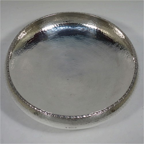 A very pretty Sterling Silver Arts and Crafts style table dish, having a round hand-hammered body, with an applied floral border, and sitting on a collet foot. Made by the Fenton Brothers Ltd., of London in 1922. The dimensions of this fine hand-made Arts and Crafts silver dish are diameter 22 cms (8.75 inches), height 7 cms (2.75 inches), and it weighs approx. 370g (12 troy ounces).    