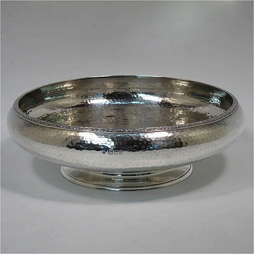 A very pretty Sterling Silver Arts and Crafts style table dish, having a round hand-hammered body, with an applied floral border, and sitting on a collet foot. Made by the Fenton Brothers Ltd., of London in 1922. The dimensions of this fine hand-made Arts and Crafts silver dish are diameter 22 cms (8.75 inches), height 7 cms (2.75 inches), and it weighs approx. 370g (12 troy ounces).    