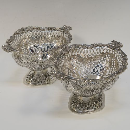 A very pretty pair of Antique Victorian Sterling Silver dishes, having oval bodies with neoclassical style decoration, hand-pierced with swags and bows and applied cast foliate borders, all sitting on matching oval pedestal feet. These beautiful antique silver dishes were made by Charles Stuart Harris of London in 1900. The dimensions of these fine hand-made silver table dishes are length 19 cms (7.5 inches), width 14 cms (5.5 inches), height 11 cms (4.3 inches), and they weigh a total of approx. 627g (20 troy ounces).   