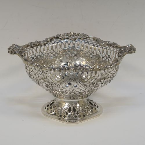 A very pretty pair of Antique Victorian Sterling Silver dishes, having oval bodies with neoclassical style decoration, hand-pierced with swags and bows and applied cast foliate borders, all sitting on matching oval pedestal feet. These beautiful antique silver dishes were made by Charles Stuart Harris of London in 1900. The dimensions of these fine hand-made silver table dishes are length 19 cms (7.5 inches), width 14 cms (5.5 inches), height 11 cms (4.3 inches), and they weigh a total of approx. 627g (20 troy ounces).   