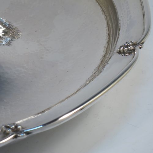 A very elegant and unusual Sterling Silver Arts and Crafts style large table fruit dish, having a round hand-hammered body, a central handle with cast grape and fruit decoration, and an applied grape border. Made by A. E. Jones of Birmingham in 1936. The dimensions of this fine hand-made silver fruit dish are diameter 31 cms (12.25 inches), height 10 cms (4 inches), and it weighs approx. 1,080g (34.8 troy ounces).  