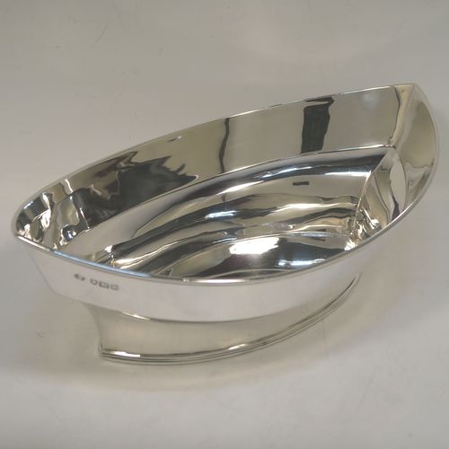 A very handsome Antique Edwardian Sterling Silver bread roll table dish, having a very plain oval boat-shaped body, with an applied reeded border, and all sitting on a flat base. This elegant antique silver bread dish was made by William Hutton of London in 1909. The dimensions of this fine hand-made antique silver bread-roll dish are length 28 cms (11 inches), width 17 cms (6.75 inches), height 9 cms (3.5 inches), and it weighs approx. 470g (15 troy ounces).  