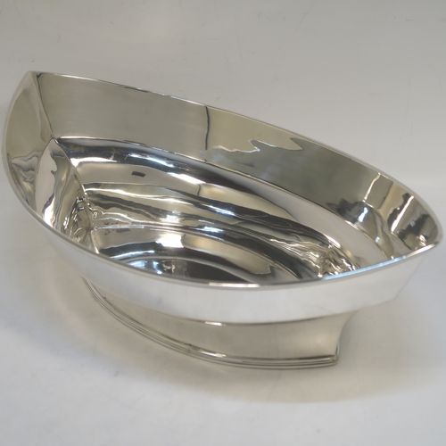 A very handsome Antique Edwardian Sterling Silver bread roll table dish, having a very plain oval boat-shaped body, with an applied reeded border, and all sitting on a flat base. This elegant antique silver bread dish was made by William Hutton of London in 1909. The dimensions of this fine hand-made antique silver bread-roll dish are length 28 cms (11 inches), width 17 cms (6.75 inches), height 9 cms (3.5 inches), and it weighs approx. 470g (15 troy ounces).  