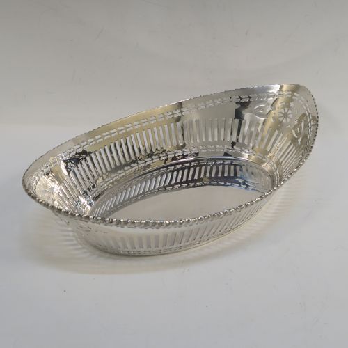 A very pretty Antique Sterling Silver bread roll table dish, having an oval body with hand-pierced geometrical and floral style decoration, an applied gadroon top border, and sitting on a flat base. This beautiful antique silver bread roll dish was made by the Barker Brothers of Chester in 1911. The dimensions of this fine hand-made silver bread dish are length 30 cms (11.75 inches), width 17.5 cms (7 inches), height 7.5 cms (3 inches), and it weighs approx. 389g (12.5 troy ounces).   