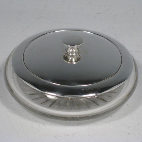    Sterling silver and hand-cut crystal dressing table jar with pull-off lid, with integral vanity mirror positioned under lid. Made by the Adie Brothers of Birmingham in 1937. Diameter 11.5 cms (4.5 inches), height 5 cms (2 inches).