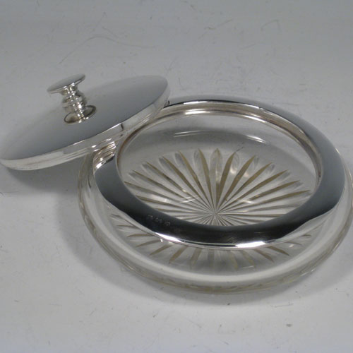    Sterling silver and hand-cut crystal dressing table jar with pull-off lid, with integral vanity mirror positioned under lid. Made by the Adie Brothers of Birmingham in 1937. Diameter 11.5 cms (4.5 inches), height 5 cms (2 inches).