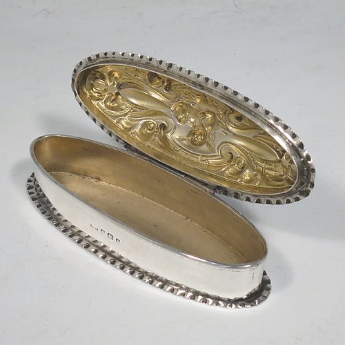 A very pretty Antique Edwardian Art Nouveau Sterling Silver dressing table box, having an oval body with crimped borders, a hinged lid with hand-chased floral, scroll, and Cherub work, and sitting on a flat base. Made by Levi & Salamon of Birmingham in 1902. The dimensions of this fine hand-made silver dressing table box are length 11 cms (4.25 inches), width 4 cms (1.5 inches), height 3 cms (1.25 inches), and it weighs approx. 165g (2 troy ounces).   