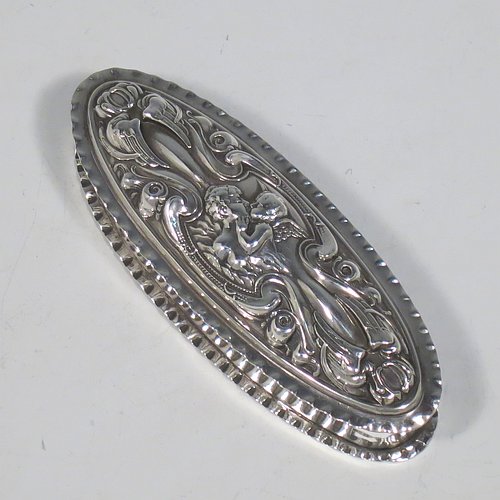 A very pretty Antique Edwardian Art Nouveau Sterling Silver dressing table box, having an oval body with crimped borders, a hinged lid with hand-chased floral, scroll, and Cherub work, and sitting on a flat base. Made by Levi & Salamon of Birmingham in 1902. The dimensions of this fine hand-made silver dressing table box are length 11 cms (4.25 inches), width 4 cms (1.5 inches), height 3 cms (1.25 inches), and it weighs approx. 165g (2 troy ounces).   