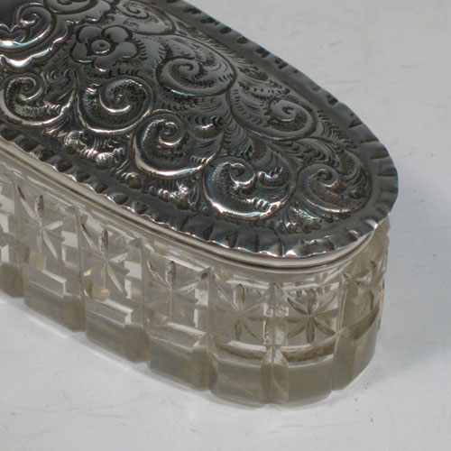 Antique Edwardian sterling silver hand-chased and cut-crystal dressing table box, made in London in 1904. Length 16.5 cms (6.5 inches), height 5 cms (2 inches), width 4.5 cms (1.75 inches).