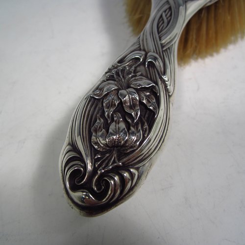 An Antique Edwardian Sterling silver Art Nouveau dressing table hair brush, having very pretty hand-chased floral and ribbon decoration, surrounding a figure of a lady. All with original bristles and wooden mount in very good condition. Made by Henry Miller of Birmingham in 1903. The dimensions of this fine hand-made hair brush are length 24 cms (9.5 inches), and width 9 cms (3.5 inches).