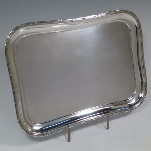 A pretty Antique Edwardian Sterling Silver dressing table tray, having a rectangular body with rounded corners, a plain ground, an applied laurel-leaf and reeded border, and all sitting on a flat base. Made by Harrison Brothers and Howson of Sheffield in 1910. The dimensions of this fine hand-made ique antsilver dressing table tray are length 30 cms (12 inches), width 22 cms (8.75 inches), and it weighs approx. 512g (16.5 troy ounces).    