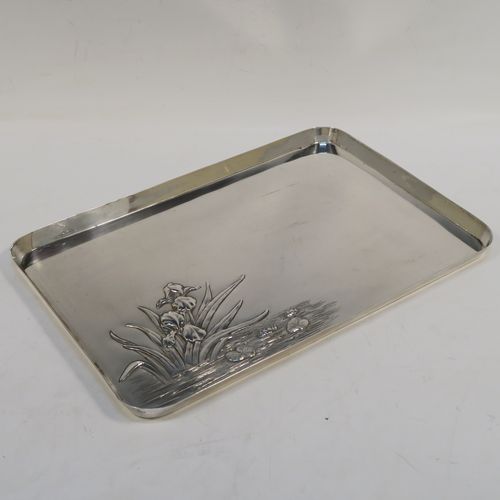 A very pretty Antique Edwardian Sterling Silver Art Nouveau style dressing table pin tray, having a rectangular body with a hand-chased area of lilies and pads in a flowing river, a raised plain outer border, and all sitting on a flat base. This beautiful antique silver dressing table tray was made by William Comyns of London in 1906. The dimensions of this fine hand-made antique silver pin tray are length 27 cms (10.5 inches), width 18.5 cms (7.25 inches), and it weighs approx. 365g (11.8 troy ounces).   