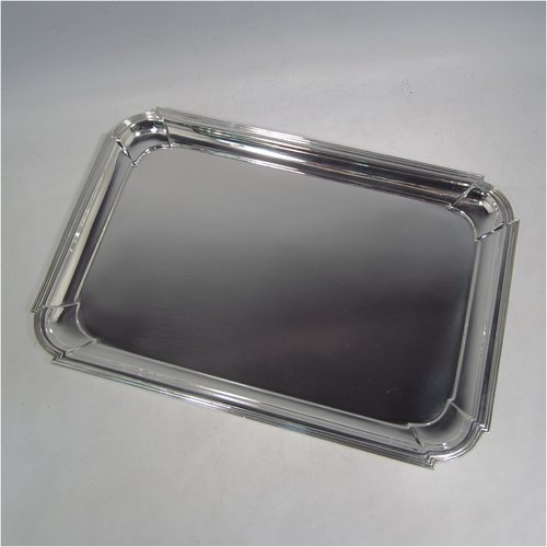 A Sterling silver Art Deco dressing table tray, having a rectangular body with cut corners, a plain ground, an applied reeded border, and  sitting on a flat base. Made by A. & J. Zimmerman of Birmingham in 1929. The dimensions of this fine hand-made silver dressing table tray are length 31 cms (12.75 inches), width 21 cms (8.25 inches), and it weighs approx. 495g (16 troy ounces).    