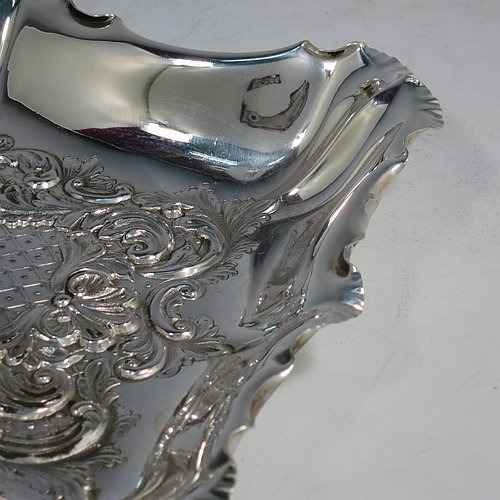 An Antique Victorian Sterling Silver Art Nouveau dressing table pin tray, having a shaped rectangular body with a raised border and hand-chased floral and scroll decoration, a central vacant cartouche, and all sitting on a flat base. Made by the Fenton Brothers of Sheffield in 1896. The dimensions of this fine hand-made antique silver pin tray are length 25 cms (10 inches), width 19 cms (7.5 inches), and it weighs approx. 294g (9.5 troy ounces).    