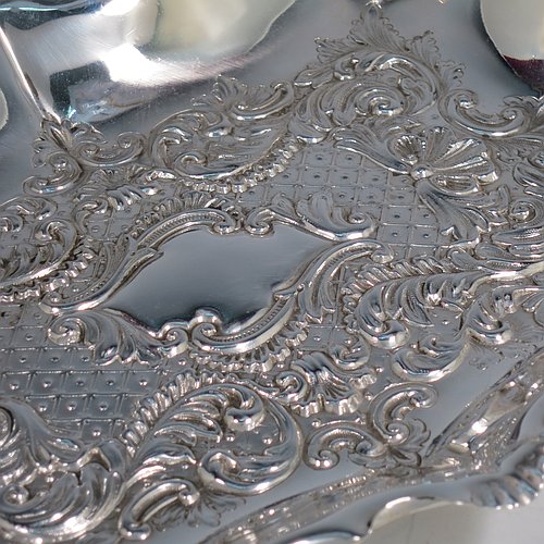 An Antique Victorian Sterling Silver Art Nouveau dressing table pin tray, having a shaped rectangular body with a raised border and hand-chased floral and scroll decoration, a central vacant cartouche, and all sitting on a flat base. Made by the Fenton Brothers of Sheffield in 1896. The dimensions of this fine hand-made antique silver pin tray are length 25 cms (10 inches), width 19 cms (7.5 inches), and it weighs approx. 294g (9.5 troy ounces).    