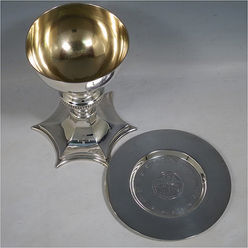 A Sterling Silver altar chalice and paten, having a plain round tapering cup with gold-gilt interior, a round column with a middle baluster and bead border, and a spreading hexagonal pedestal foot, together with a plain round paten with hand-engraved cross. The chalice made by Frederick Osborne of London in 1931, and the paten by Jones and Willis of London in 1908. The dimensions of this fine hand-made silver chalice & paten are height 15 cms (6 inches), diameter of cup 10 cms (4 inches), diameter of paten 13.5 cms (5.3 inches), and it weighs a total of 455g (14.7 troy ounces). 