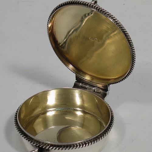 A handsome Sterling Silver Pyx box, having a plain round body with applied rope-twist borders, a hinged lid with a hand-engraved Christogram, a gold-gilt interior, and with a pair of ring handles. Made by B. & W. Ltd., of London in 1960. The dimensions of this fine hand-made silver Pyx box are diameter 5 cms (2 inches), depth 2 cms (0.5 inches), and it weighs approx. 52g (1.7 troy ounces).    