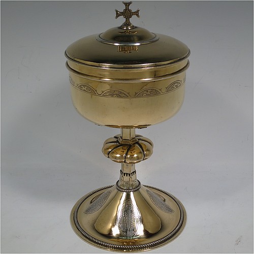 A very beautiful Sterling Silver and Gold-Gilt Ciborium, having a round body with a band of hand-engraved floral motifs, a plain round lift-off lid with cast cruciform finial, a hand-chased swirl-fluted central baluster, and all sitting on a round pedestal foot base with hand-engraved oval cartouches of wheat-sheaves and applied rope-twist borders. Made by Hayes and Finch Ltd., of London in 1951. The dimensions of this fine hand-made silver and gold-gilt ciborium are height 23.5 cms (9.25 inches), diameter of cup 12 cms (4.75 inches), and it weighs a total of approx. 730g (23.5 troy ounces).    