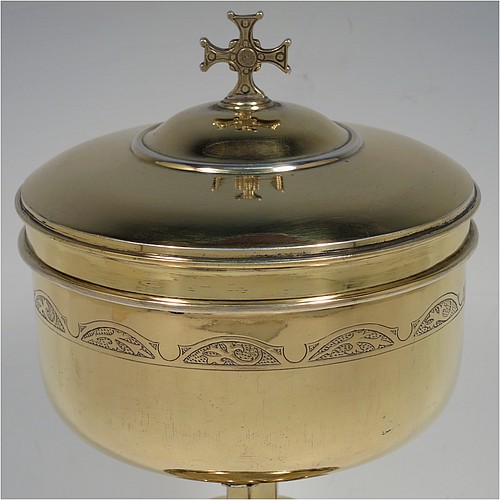 A very beautiful Sterling Silver and Gold-Gilt Ciborium, having a round body with a band of hand-engraved floral motifs, a plain round lift-off lid with cast cruciform finial, a hand-chased swirl-fluted central baluster, and all sitting on a round pedestal foot base with hand-engraved oval cartouches of wheat-sheaves and applied rope-twist borders. Made by Hayes and Finch Ltd., of London in 1951. The dimensions of this fine hand-made silver and gold-gilt ciborium are height 23.5 cms (9.25 inches), diameter of cup 12 cms (4.75 inches), and it weighs a total of approx. 730g (23.5 troy ounces).    