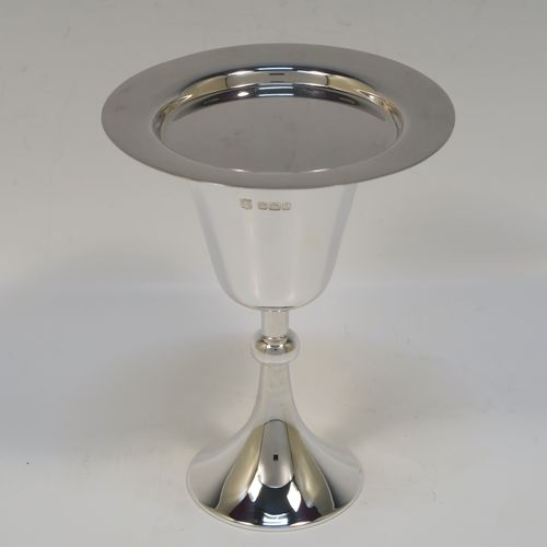 An elegant Antique Sterling Silver travelling communion chalice, having a plain round tapering cup with a gold-gilt interior, a round column with a middle baluster, and a spreading round pedestal foot, together with a matching plain round paten. The chalice was made by the Dixon Brothers of Sheffield in 1911, whilst the paten was made by A. E. Jones of Sheffield in 1962. The dimensions of this fine hand-made antique silver chalice & paten are height of chalice 12 cms (4.75 inches), diameter of paten 10 cms (4 inches), and the total weight is 137g (4.4 troy ounces).   