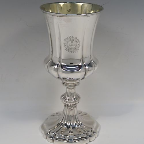 A large and very handsome Antique early Victorian Sterling Silver altar chalice, having a round bellied body with hand-chased melon fluting and a gold-gilt interior, and sitting on a spreading melon-fluted pedestal foot. This large and beautiful silver chalice was made by Henry Wilkinson of Sheffield in 1839. The dimensions of this fine hand-made antique silver altar chalice are height 23 cms (9 inches), diameter at lip 10 cms (4 inches), and it weighs approx. 435g (14 troy ounces). Please note that this item is engraved with a sun-burst Christogram.