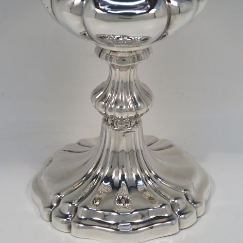 A large and very handsome Antique early Victorian Sterling Silver altar chalice, having a round bellied body with hand-chased melon fluting and a gold-gilt interior, and sitting on a spreading melon-fluted pedestal foot. This large and beautiful silver chalice was made by Henry Wilkinson of Sheffield in 1839. The dimensions of this fine hand-made antique silver altar chalice are height 23 cms (9 inches), diameter at lip 10 cms (4 inches), and it weighs approx. 435g (14 troy ounces). Please note that this item is engraved with a sun-burst Christogram.