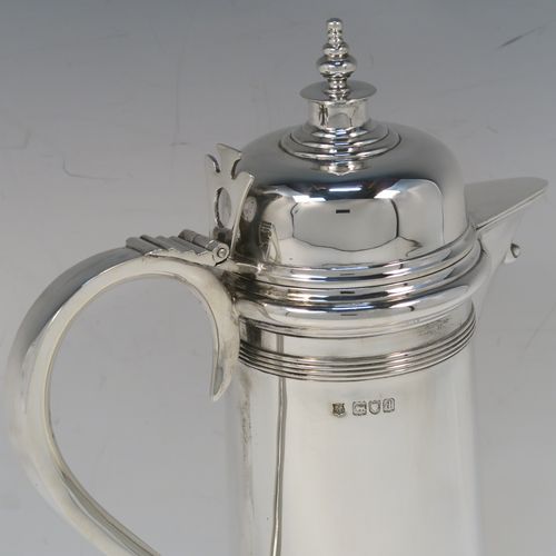 A handsome Antique Victorian Sterling Silver ecclesiastical wine flagon ewer, having a round straight-sided body and applied reeded bands, a side scroll handle, together with a hinged domed lid and cast round finial, a covered sparrow-beak spout, and sitting on a spreading collet foot. This elegant silver church consecrated wine flagon was made by William Gibson and John Langland of London in 1899. The dimensions of this fine hand-made antique silver flagon or ewer are height 24 cms (9.5 inches), diameter at base 11 cms (4.25 inches), and it weighs approx. 677g (21.8 troy ounces).   