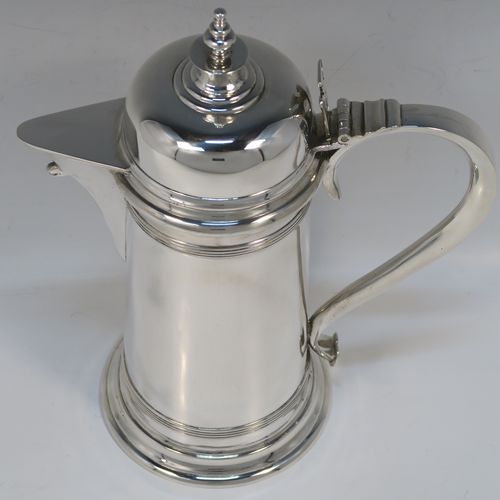 A handsome Antique Victorian Sterling Silver ecclesiastical wine flagon ewer, having a round straight-sided body and applied reeded bands, a side scroll handle, together with a hinged domed lid and cast round finial, a covered sparrow-beak spout, and sitting on a spreading collet foot. This elegant silver church consecrated wine flagon was made by William Gibson and John Langland of London in 1899. The dimensions of this fine hand-made antique silver flagon or ewer are height 24 cms (9.5 inches), diameter at base 11 cms (4.25 inches), and it weighs approx. 677g (21.8 troy ounces).   