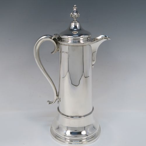 A handsome and large Antique Victorian Sterling Silver ecclesiastical wine flagon ewer, having a round straight-sided body with tapering sides and  applied reeded bands, a side scroll handle, together with a hinged domed lid and cast fluted finial, a sparrow-beak spout, and sitting on a spreading collet foot. This elegant silver church consecrated wine flagon was made by the Barnard Brothers of London in 1850. The dimensions of this fine hand-made antique silver flagon or ewer are height 34.5 cms (13.5 inches), diameter at base 14.5 cms (5.75 inches), and it weighs approx. 980g (31.6 troy ounces).   