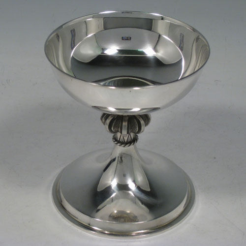 Sterling silver chalice in an Arts and Crafts style, having a plain round cup, a cast octafoil central stem with applied gadroon band, and sitting on a spreading pedestal foot, all in its original satin and velvet-lined presentation box. Made by A. E. Jones of Birmingham in 1972. The dimensions of this fine hand-made silver chalice are height 10 cms (4 inches), diameter 9 cms (3.5 inches), and it weighs approx. 180g (5.8 troy ounces).