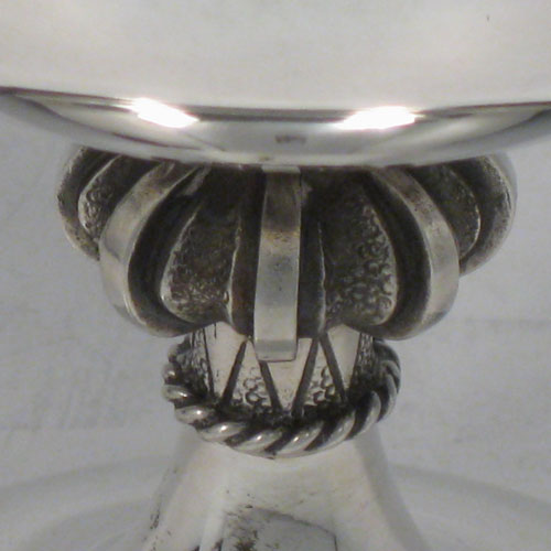 Sterling silver chalice in an Arts and Crafts style, having a plain round cup, a cast octafoil central stem with applied gadroon band, and sitting on a spreading pedestal foot, all in its original satin and velvet-lined presentation box. Made by A. E. Jones of Birmingham in 1972. The dimensions of this fine hand-made silver chalice are height 10 cms (4 inches), diameter 9 cms (3.5 inches), and it weighs approx. 180g (5.8 troy ounces).