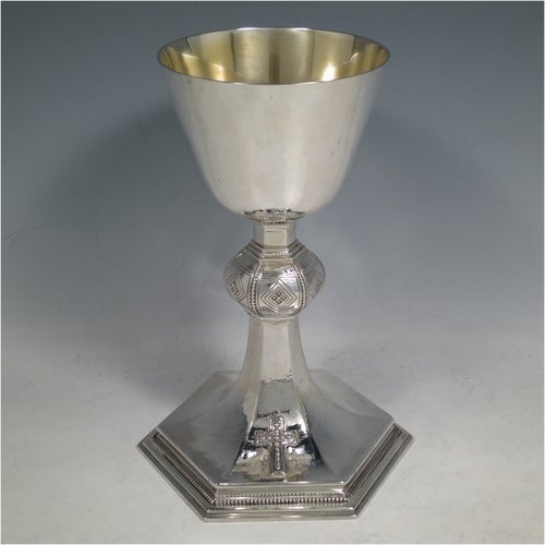 A Sterling Silver Chalice having a round body with a hand-hammered finish, a hexagonal pedestal foot with a central baluster, having applied bead borders, a gold-gilt interior, and a hand-chased crucifix. Made by Frederick Osbourne of London in 1933. The dimensions of this fine hand-made chalice are height 20 cms (8 inches), diameter at lip 10 cms (4 inches), and it weighs approx. 682g (22 troy ounces).   