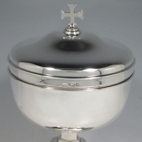 Sterling silver Ciborium, having a plain round body, sitting on a hexafoil base with hand-chased grape-vine border, a lift-off lid with crucifix finial, and gold-gilt interior. Made by Francis Tucker and Co. Ltd., of London in 1940. The dimensions of this fine hand-made silver ciborium are height 22 cms (8.75 inches), diameter 12 cms (5 inches), and it weighs a total of approx. 618g (20 troy ounces). 