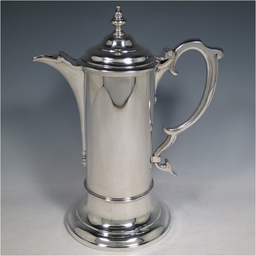 An Antique Victorian Sterling Silver communion service composed of a flagon and two goblets. The flagon in an early 17th century style having a straight-sided body, a scroll handle, a hinged & domed lid with urn-shaped finial, a matching scrolled spout and sitting on a collet foot. Together with a pair of plain round baluster goblets with gold-gilt interiors. All made by Robert Garrard of London in 1862/63. The dimensions of this fine hand-made communion set are height of flagon 29 cms (11.5 inches), length across handle & spout 23 cms (9 inches), height of goblets 18 cms (7 inches), and with a total weight of approx. 1,643g (53 troy ounces).   