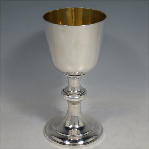 An Antique Victorian Sterling Silver communion service composed of a flagon and two goblets. The flagon in an early 17th century style having a straight-sided body, a scroll handle, a hinged & domed lid with urn-shaped finial, a matching scrolled spout and sitting on a collet foot. Together with a pair of plain round baluster goblets with gold-gilt interiors. All made by Robert Garrard of London in 1862/63. The dimensions of this fine hand-made communion set are height of flagon 29 cms (11.5 inches), length across handle & spout 23 cms (9 inches), height of goblets 18 cms (7 inches), and with a total weight of approx. 1,643g (53 troy ounces).   