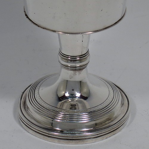 An Antique Georgian Sterling Silver small travelling communion chalice with reeded borders, having a round cup with tapering sides and a hand-engraved upper band of grape-vine decoration, a middle baluster with an applied reeded band, and sitting on a round pedestal foot. Made by Thomas Wallis II and Jonathan Hayne of London in 1812. The dimensions of this fine hand-made antique silver travelling communion chalice are height 10 cms (4 inches), diameter at lip 5 cms (2 inches), and it weighs approx. 84g (2.7 troy ounces).    