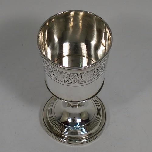 An Antique Georgian Sterling Silver small travelling communion chalice with reeded borders, having a round cup with tapering sides and a hand-engraved upper band of grape-vine decoration, a middle baluster with an applied reeded band, and sitting on a round pedestal foot. Made by Thomas Wallis II and Jonathan Hayne of London in 1812. The dimensions of this fine hand-made antique silver travelling communion chalice are height 10 cms (4 inches), diameter at lip 5 cms (2 inches), and it weighs approx. 84g (2.7 troy ounces).    