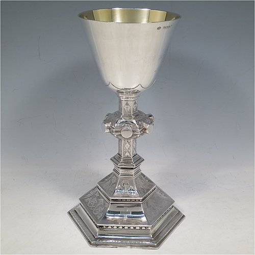 An Antique Victorian Sterling Silver large altar chalice, having a plain round cup with tapering sides and gold-gilt interior, an octagonal column with middle baluster and engraved panels, and a spreading octagonal foot with hand-pierced borders and hand-engraved floral and scroll decoration. Made by Robert Stebbings of London in 1885. The dimensions of this fine hand-made antique silver altar chalice are height 24 cms (9.5 inches), width at base 12.5 cms (5 inches), and it weighs approx. 453g (14.6 troy ounces).   