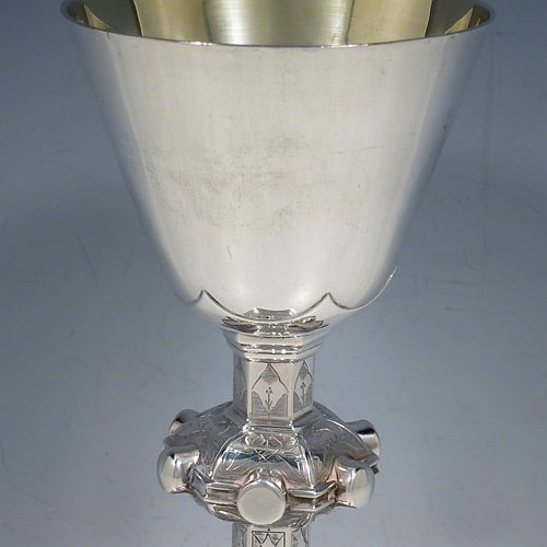 An Antique Victorian Sterling Silver large altar chalice, having a plain round cup with tapering sides and gold-gilt interior, an octagonal column with middle baluster and engraved panels, and a spreading octagonal foot with hand-pierced borders and hand-engraved floral and scroll decoration. Made by Robert Stebbings of London in 1885. The dimensions of this fine hand-made antique silver altar chalice are height 24 cms (9.5 inches), width at base 12.5 cms (5 inches), and it weighs approx. 453g (14.6 troy ounces).   