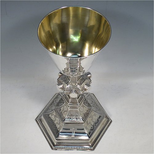 An Antique Victorian Sterling Silver large altar chalice, having a plain round cup with tapering sides and gold-gilt interior, an octagonal column with middle baluster and engraved panels, and a spreading octagonal foot with hand-pierced borders and hand-engraved floral and scroll decoration. Made by Robert Stebbings of London in 1885. The dimensions of this fine hand-made antique silver altar chalice are height 24 cms (9.5 inches), width at base 12.5 cms (5 inches), and it weighs approx. 453g (14.6 troy ounces).   