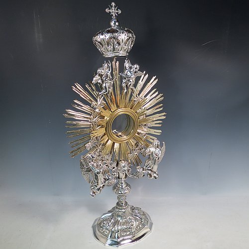 An Antique Victorian Sterling Silver and gold-gilt Belgian Monstrance, for holding the consecrated host, with crown finial above two cast cherub figures, a sun-burst relic Luna holder with two cast angel figures below, and sitting on a hand-chased oval shaped pedestal foot. Made by M. Decury of Belgium between 1831 and 1868. The dimensions of this fine hand-made antique silver Monstrance are height 71 cms (28 inches), depth 15 cms (6 inches), and width 33 cms (13 inches), with a total weight of approx. 97 troy ounces (3,000g).   