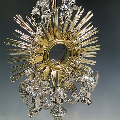 An Antique Victorian Sterling Silver and gold-gilt Belgian Monstrance, for holding the consecrated host, with crown finial above two cast cherub figures, a sun-burst relic Luna holder with two cast angel figures below, and sitting on a hand-chased oval shaped pedestal foot. Made by M. Decury of Belgium between 1831 and 1868. The dimensions of this fine hand-made antique silver Monstrance are height 71 cms (28 inches), depth 15 cms (6 inches), and width 33 cms (13 inches), with a total weight of approx. 97 troy ounces (3,000g).   