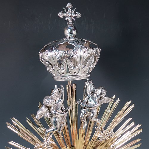 An Antique Victorian Sterling Silver and gold-gilt Belgian Monstrance, for holding the consecrated host, with crown finial above two cast cherub figures, a sun-burst relic Luna holder with two cast angel figures below, and sitting on a hand-chased oval shaped pedestal foot. Made by M. Decury of Belgium between 1831 and 1868. The dimensions of this fine hand-made antique silver Monstrance are height 71 cms (28 inches), depth 15 cms (6 inches), and width 33 cms (13 inches), with a total weight of approx. 97 troy ounces (3,000g).   