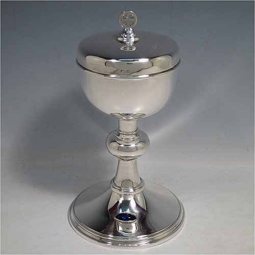 A Sterling Silver Ciborium, having a plain round body, sitting on a matching pedestal foot with an applied oval dark blue cabochon stone, with reeded borders, and a lift-off lid with cruciform finial. Made by Frederick Osborne & Co., of Birmingham in 1930. The dimensions of this fine hand-made silver ciborium are height 20 cms (8 inches), diameter of cup 9.5 cms (3.75 inches), and it weighs a total of approx. 385g (12.5 troy ounces).    