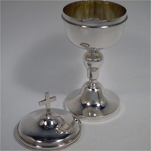 An Antique Edwardian Sterling Silver Ciborium, having a plain round body with reeded borders and gold-gilt interior, sitting on a matching pedestal foot with central baluster, and a lift-off lid with cruciform finial. Made by Henry Lambert of London in 1902. The dimensions of this fine hand-made antique silver ciborium are height 19 cms (7.5 inches), diameter of cup 8.5 cms (3.3 inches), and it weighs a total of approx. 264g (8.5 troy ounces).    