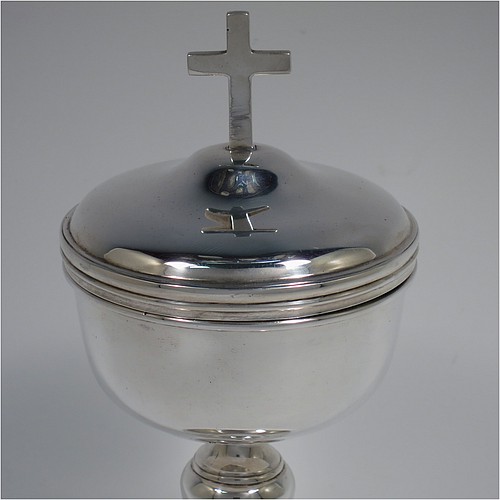 An Antique Edwardian Sterling Silver Ciborium, having a plain round body with reeded borders and gold-gilt interior, sitting on a matching pedestal foot with central baluster, and a lift-off lid with cruciform finial. Made by Henry Lambert of London in 1902. The dimensions of this fine hand-made antique silver ciborium are height 19 cms (7.5 inches), diameter of cup 8.5 cms (3.3 inches), and it weighs a total of approx. 264g (8.5 troy ounces).    