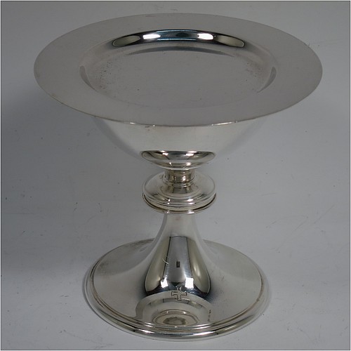 A small Sterling Silver altar chalice and paten, having a plain round bellied cup, a round column with a middle baluster, and a spreading round pedestal foot with reeded borders, together with a plain round original paten. Made by H. F. and Co. Ltd. of London in 1965. The dimensions of this fine hand-made silver chalice and paten are height 10 cms (4 inches), diameter of paten 11 cms (4.25 inches), with a total weight of approx. 203g (6.5 troy ounces). 